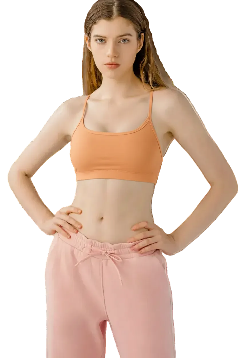 Woman wearing a black sports bra and pink pants on a white background