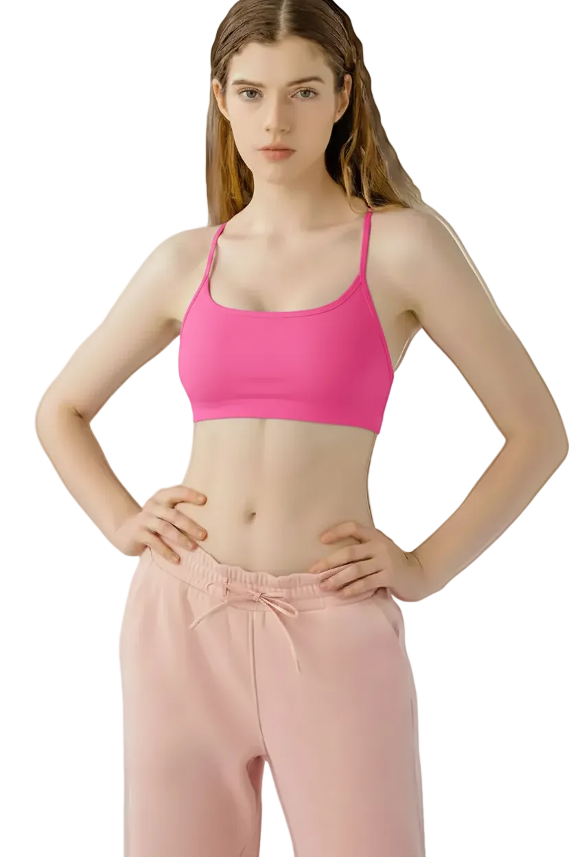 Woman wearing a black sports bra and pink pants on a white background