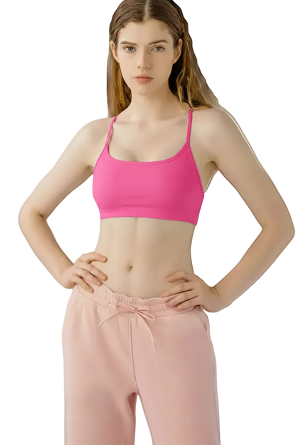 Woman wearing a black sports bra and pink pants on a white background