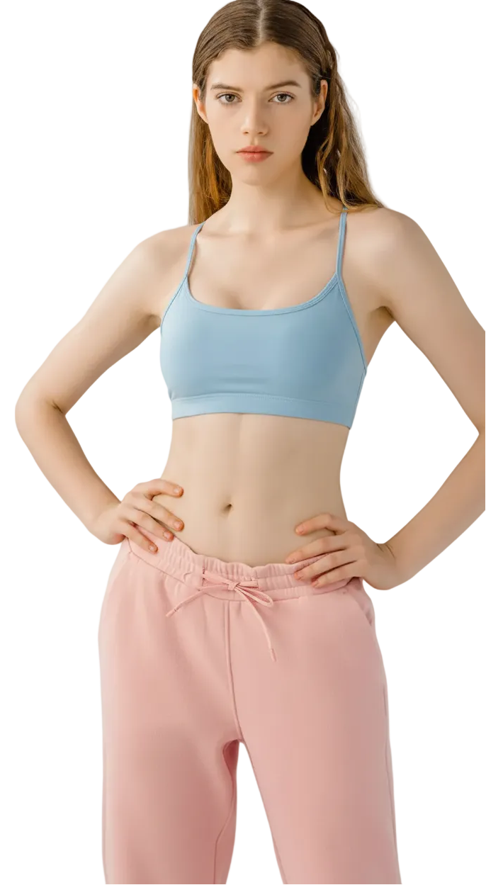 Woman wearing a black sports bra and pink pants on a white background