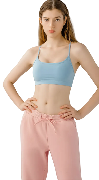 Woman wearing a black sports bra and pink pants on a white background