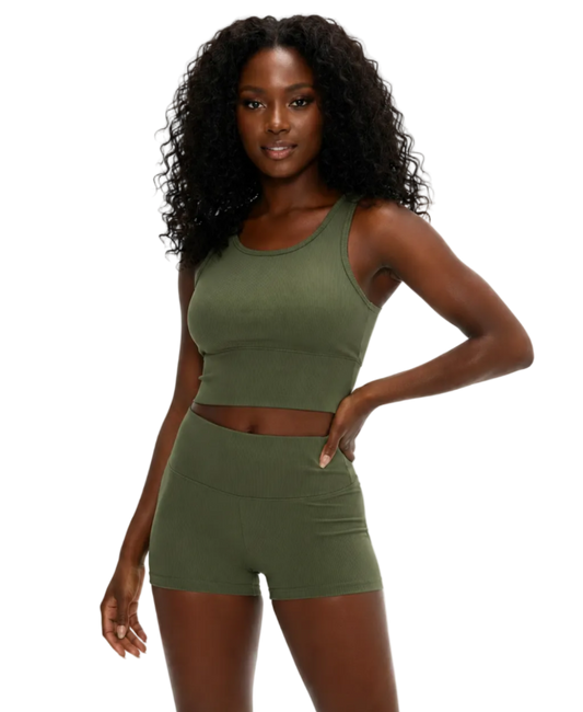 Woman wearing a green athletic outfit on a white background