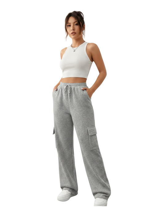 Woman wearing a white crop top and gray sweatpants on a white background